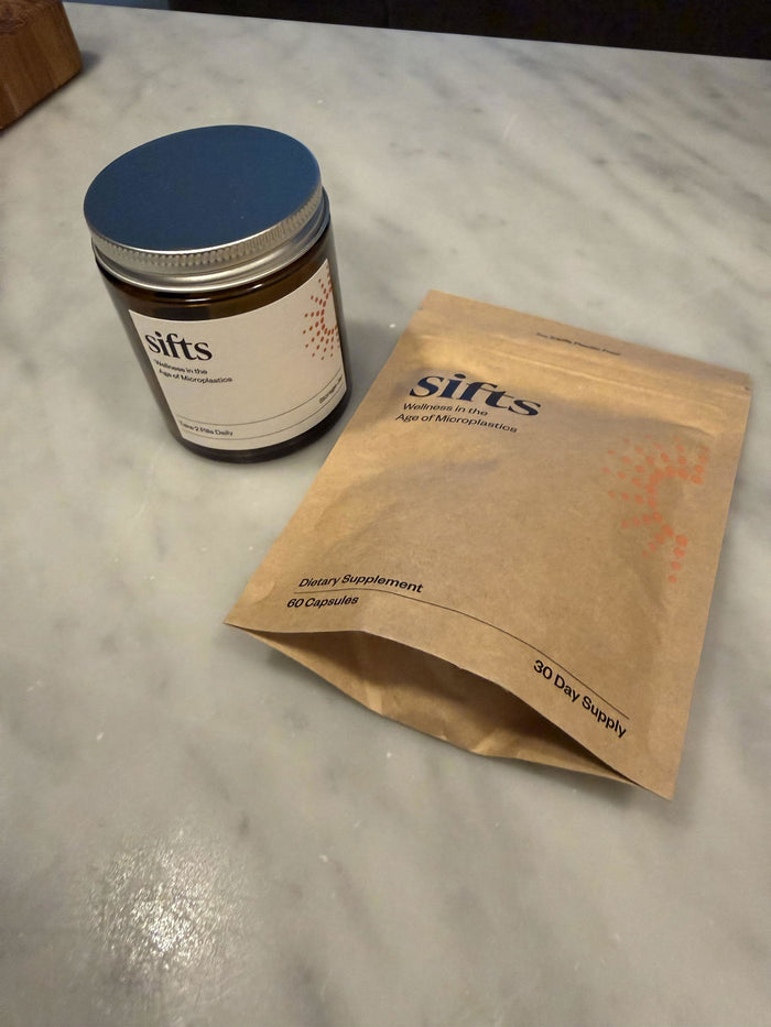 Sifts Daily amber glass jar and refill pouch on a marble counter